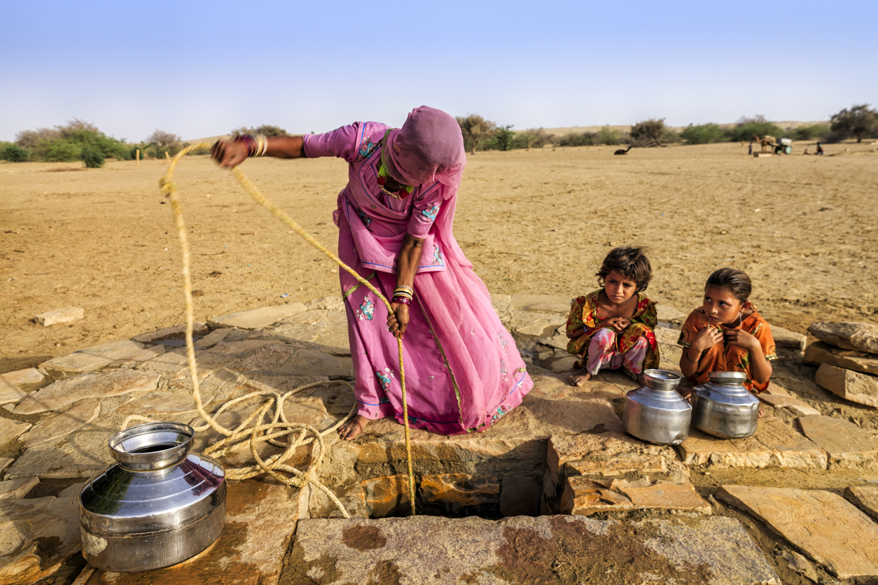 Indian woman drawing water from the well, desert, Rajasthan