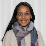 Brown woman with a smile, multicolour scarf over an off white sweater