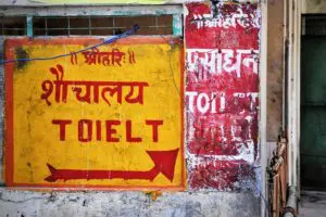 Toilet sign next to slums near Haridwar, India.