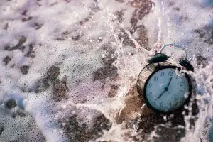 Alarm clock splashing in the beach water
