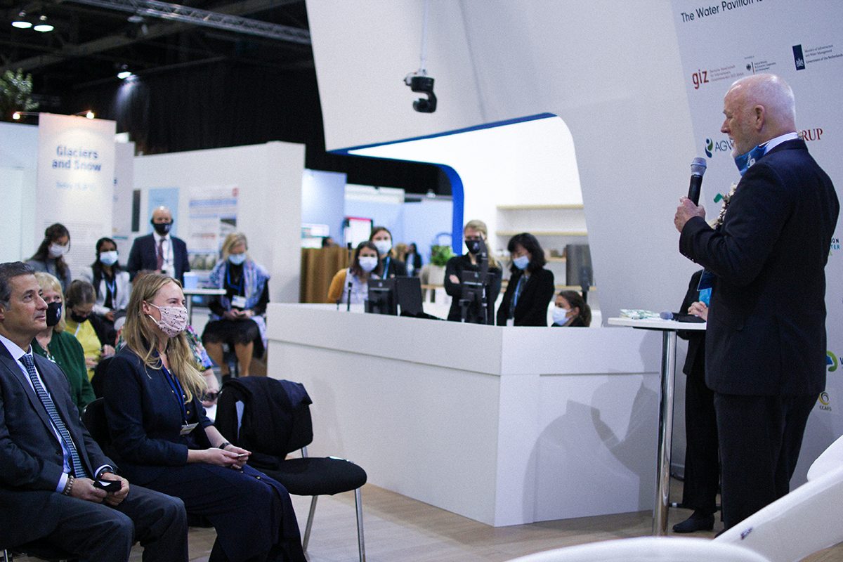 Water Pavilion at COP26: Peter Thomson, UN Special Envoy for the Ocean, speaking in front of a group of people sitting